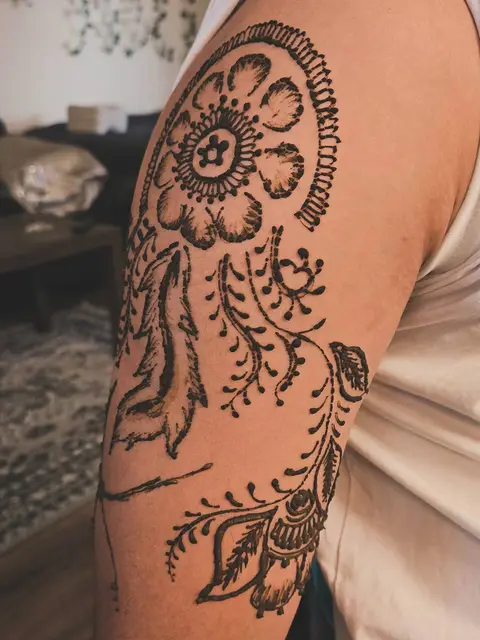 A large flower and a hanging vine drawn on the upper arm