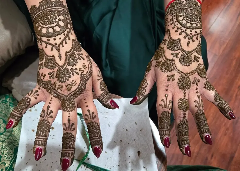 The backs of two hands with full traditional henna from wrist to fingertip